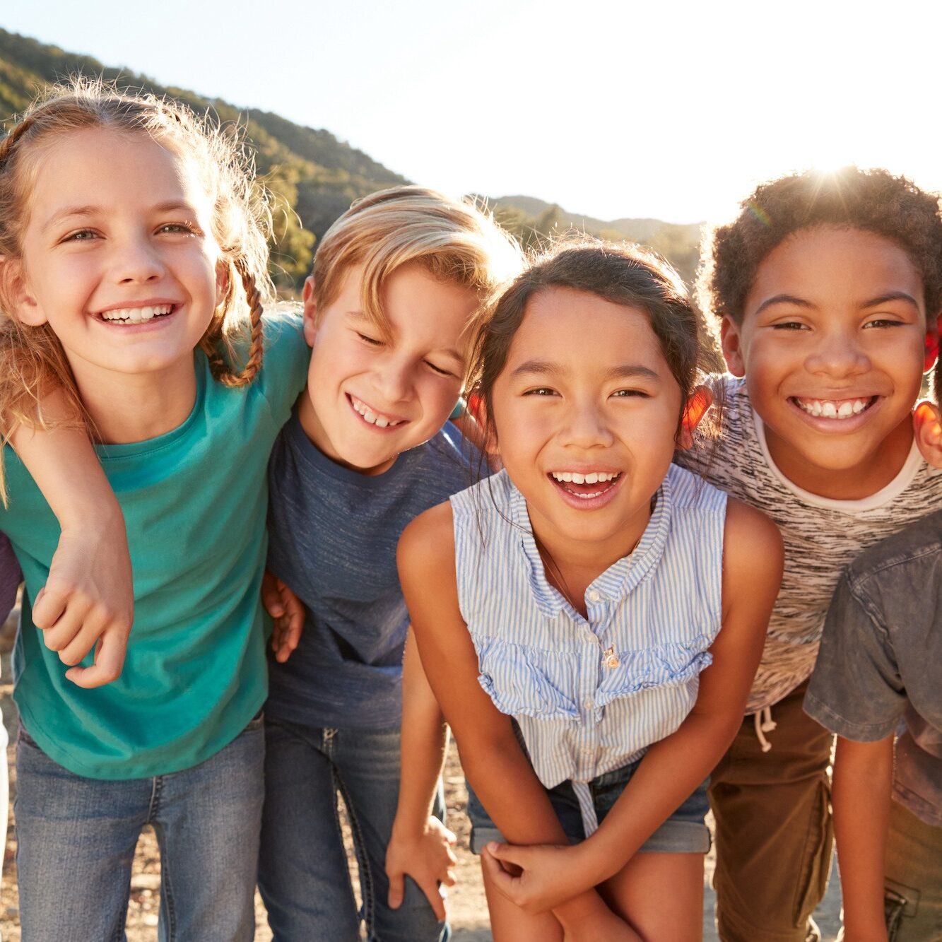 Portrait Of Multi-Cultural Children Hanging Out With Friends In Countryside Together